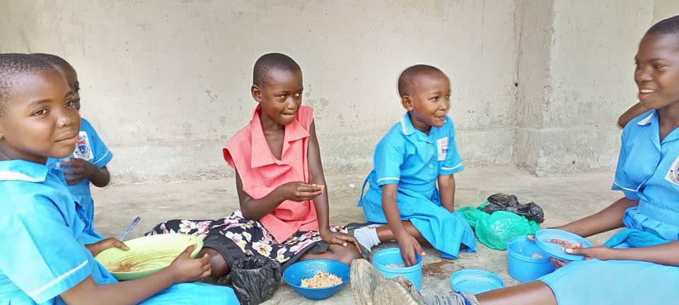Ugandan family receiving food assistance and community support from Amirah Charity Foundation